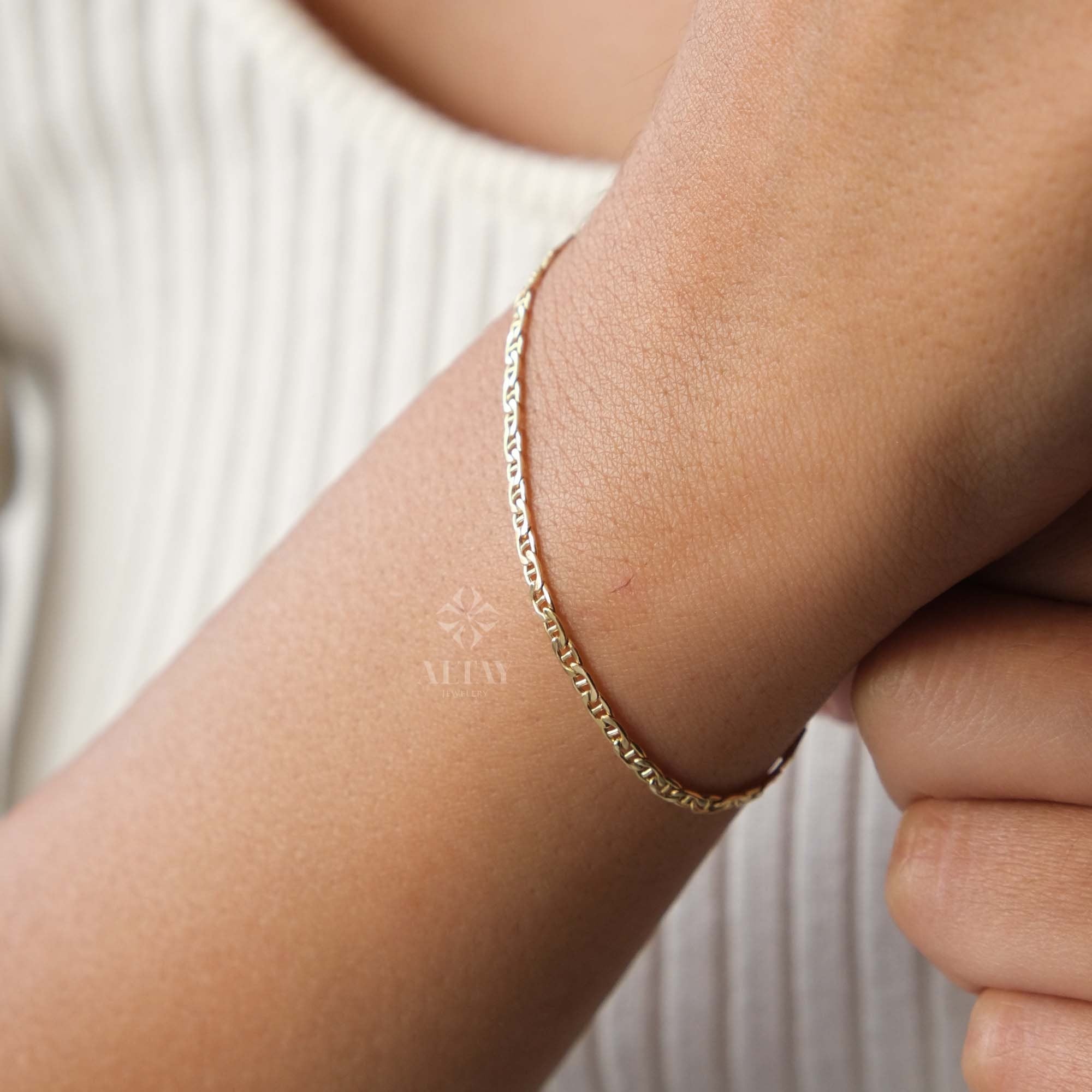 May include: A delicate gold chain bracelet. The bracelet features a series of small, interlocking links. The jewelry is worn on the wrist. The bracelet is a simple, elegant accessory.