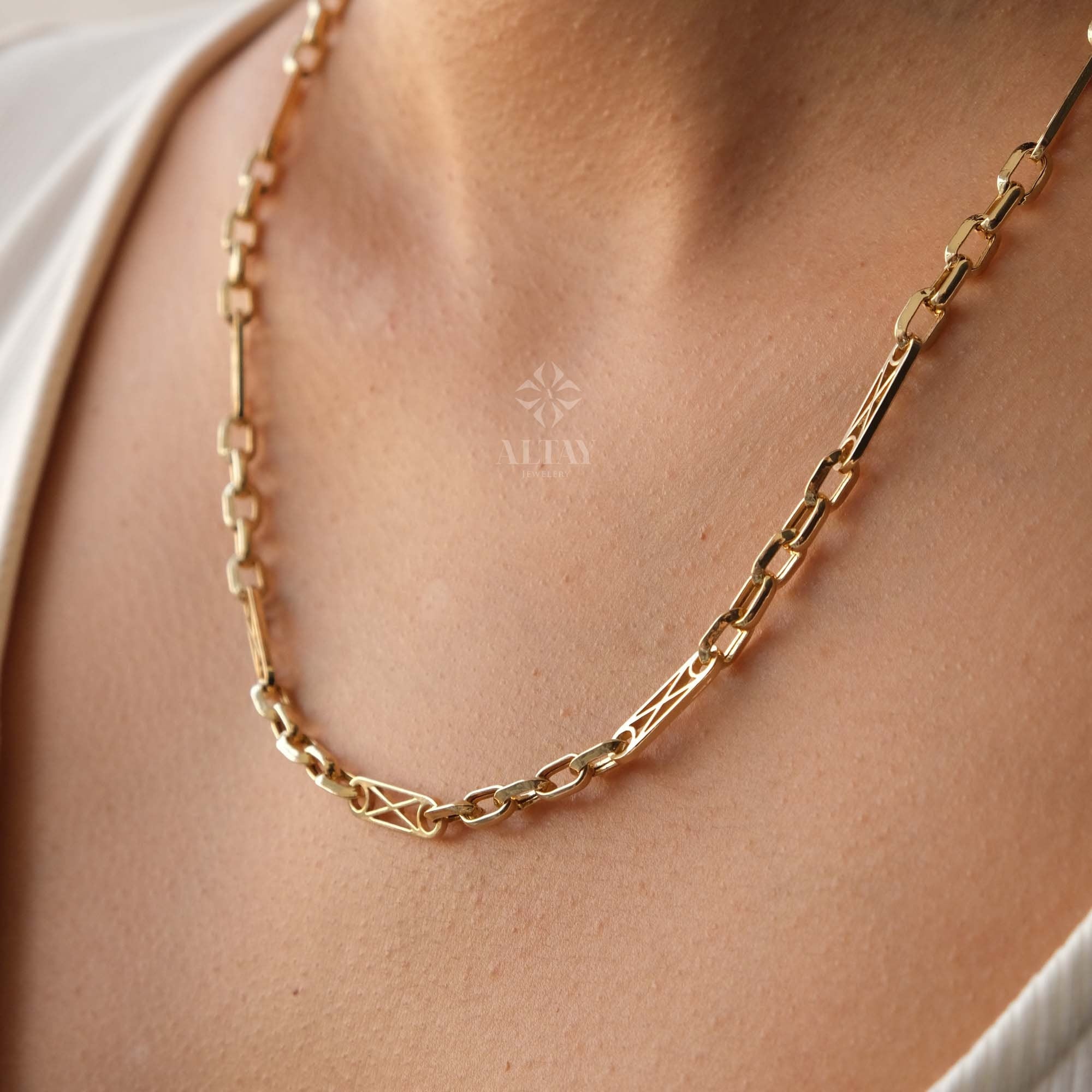 May include: A gold chain necklace with a square link design. The chain is made of a thick, durable metal and has a polished finish.