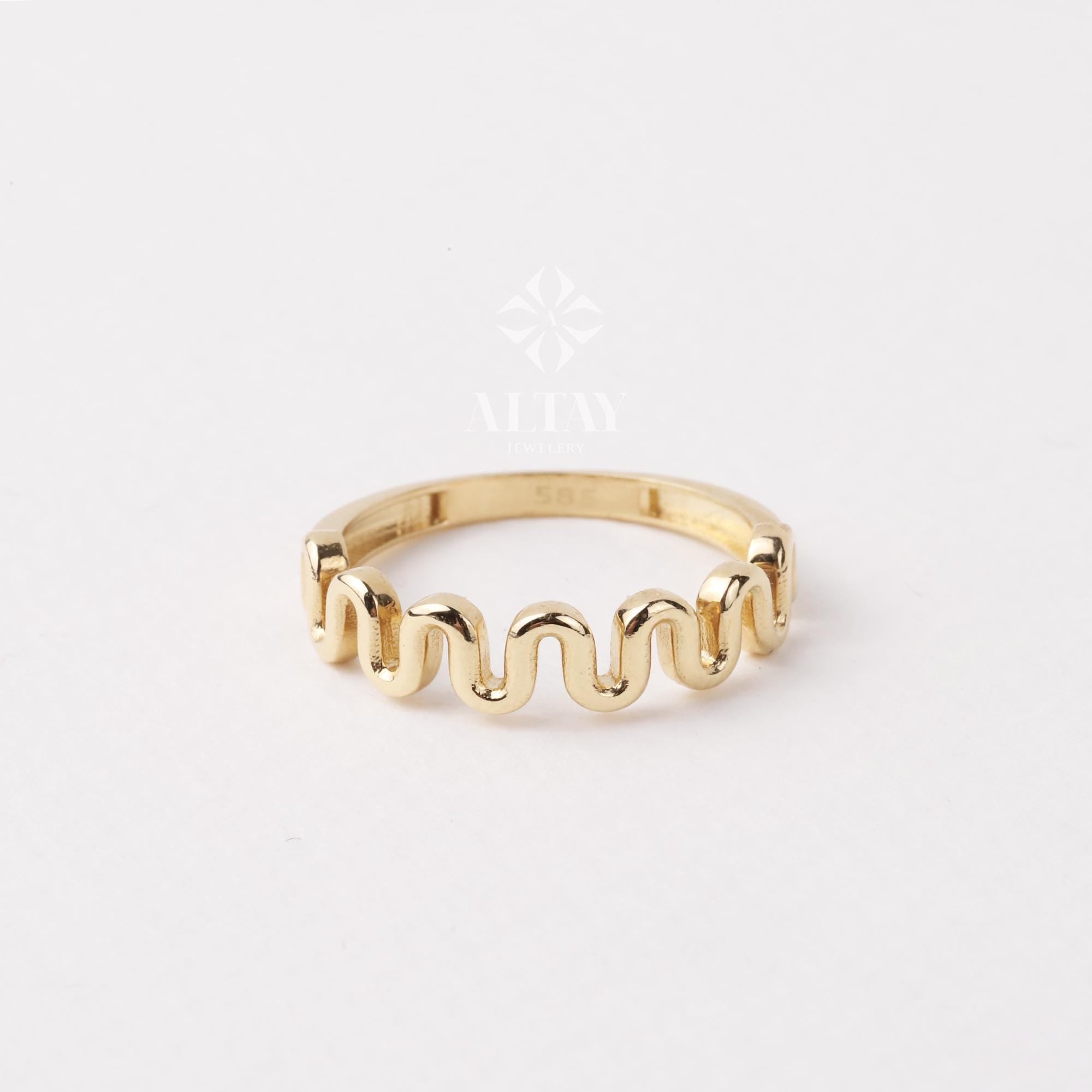 May include: A gold ring with a wavy, textured band.