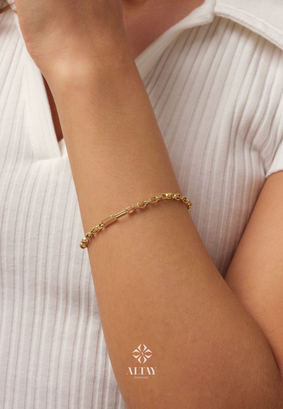 May include: A gold chain bracelet with a clasp closure. The bracelet is on a person's wrist.